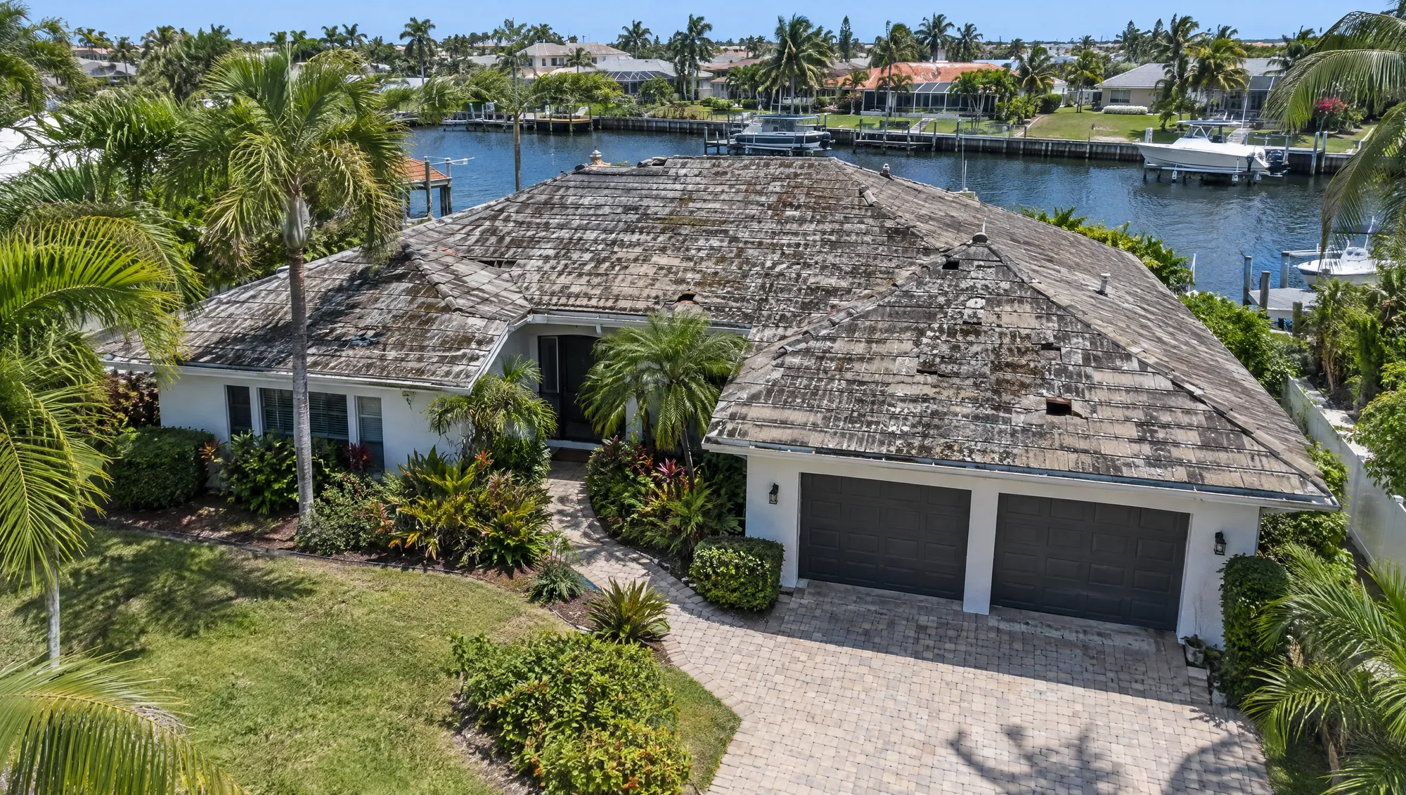 The same home before, with a stained, aging tile roof